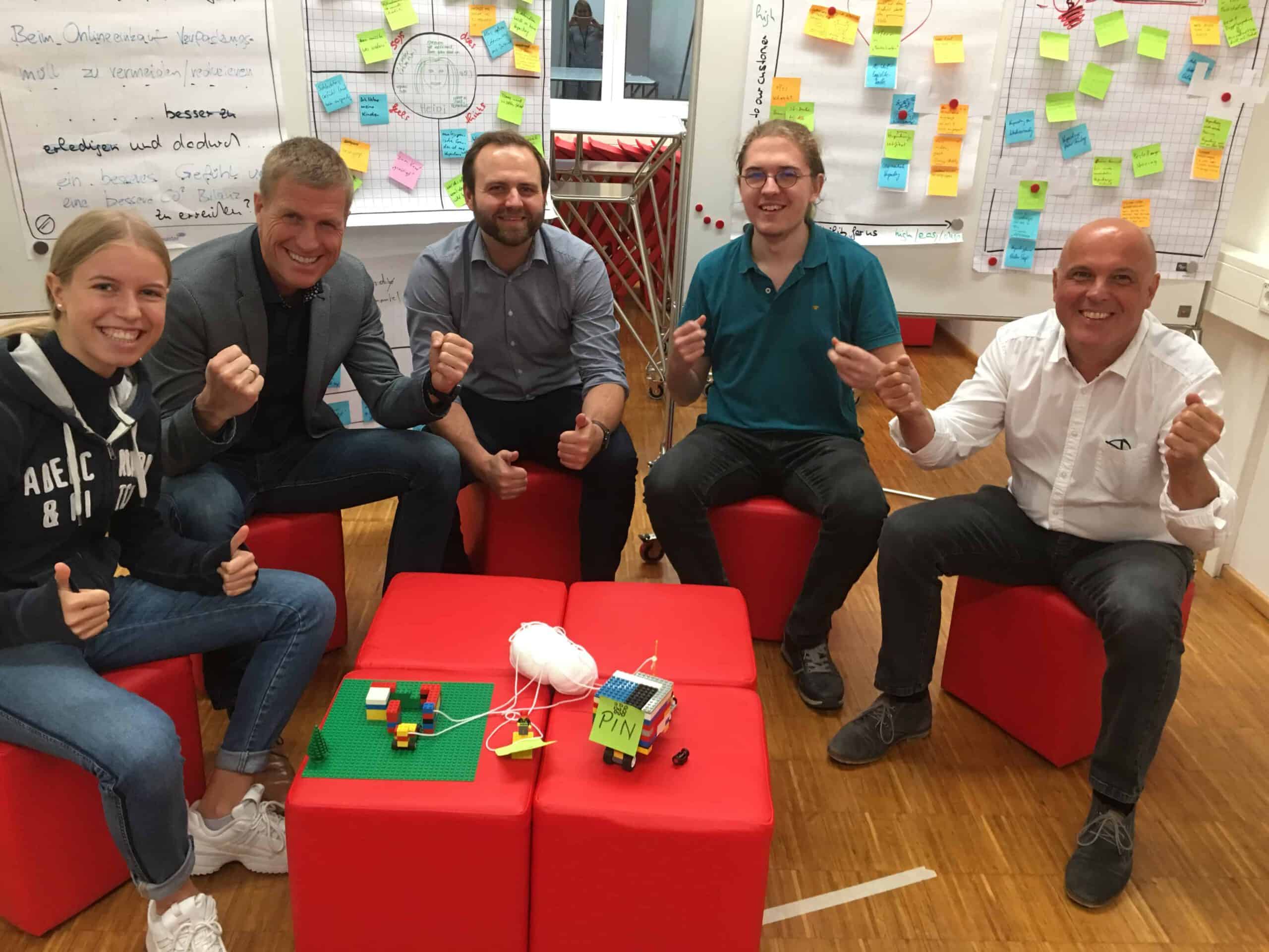 Design_Thinking_Team_ist_happy fuenf glueckliche Dsign Thinking Teilnehmer mit Prototyp